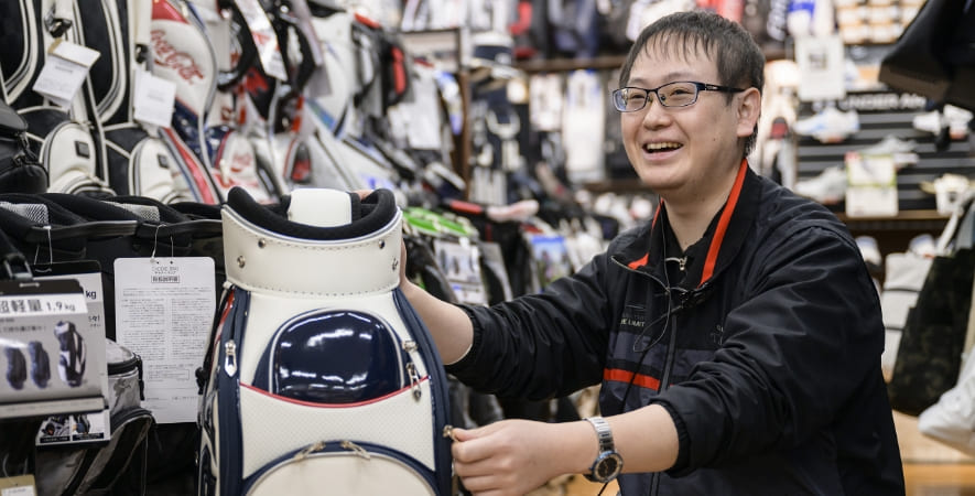 Nさん ゴルフバッグ前で接客している写真