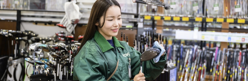 スタッフがゴルフクラブを磨いている写真